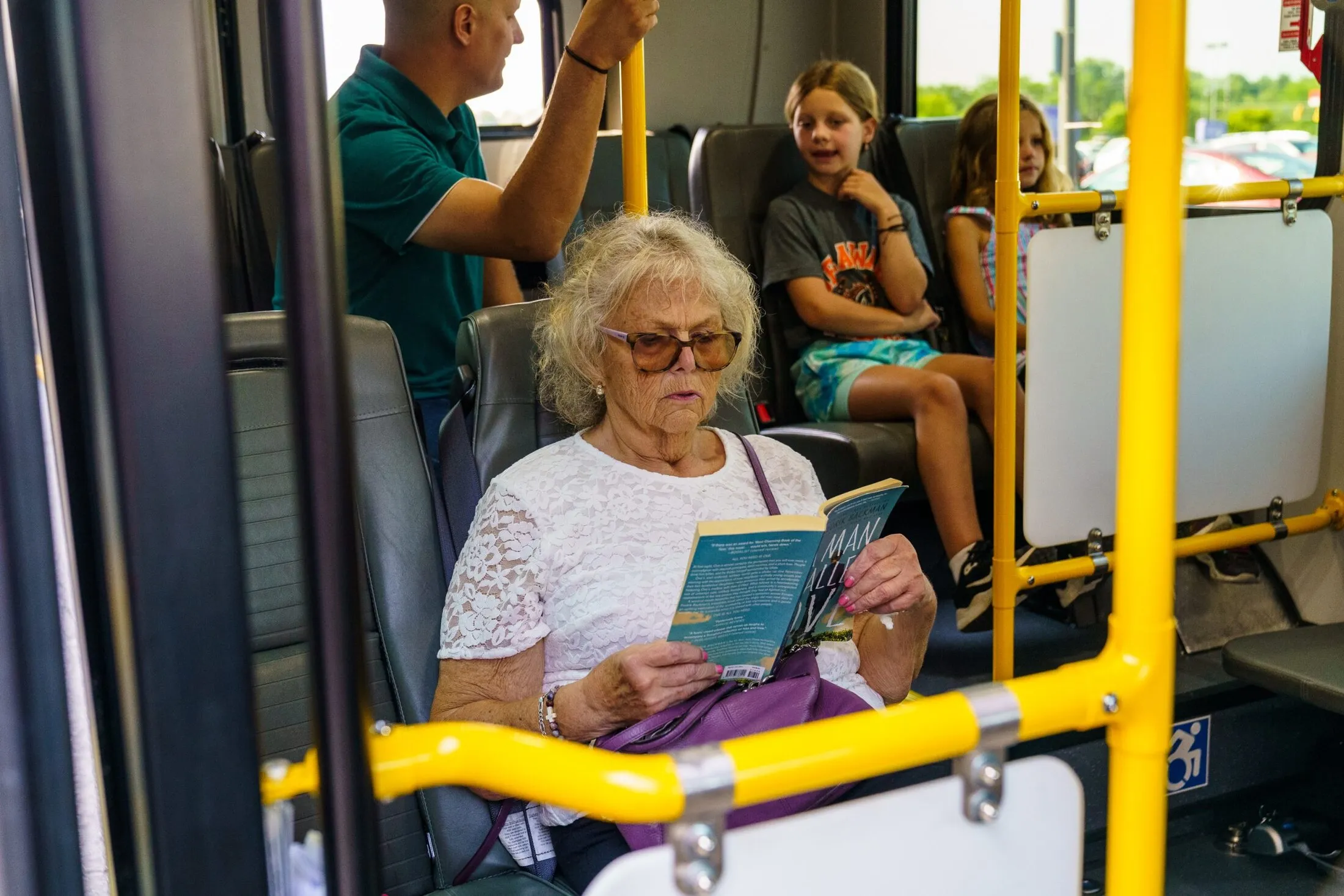 An older rider reads a book on board a DCT vehicle
