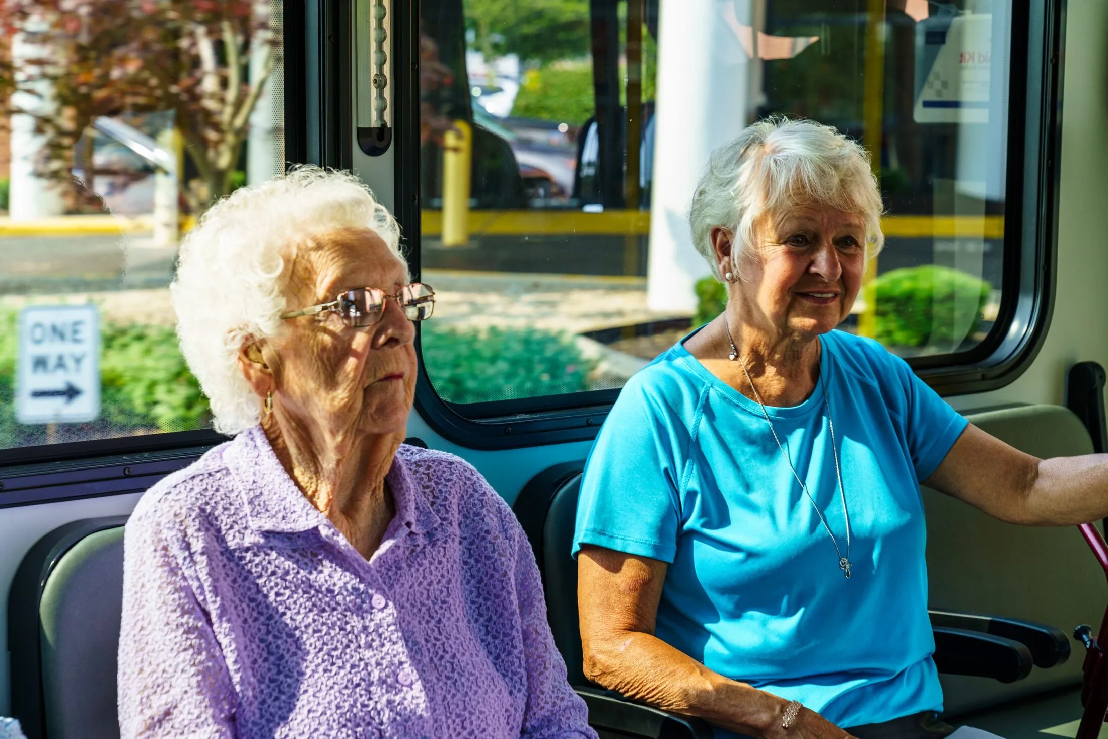 Two older riders smiling in their seats on a DCT vehicle